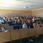 Uczestnicy podczas warsztatów. Siedzą na krzesełkach w auli.