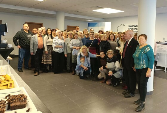 Uczestnicy Wirtualnego Klubu Seniora. Zdjęcie grupowe przed aulą WSzS.