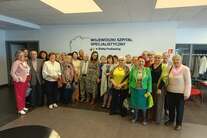 Uczestnicy Wirtualnego Klubu Seniora. Zdjęcie grupowe przed aulą WSzS.