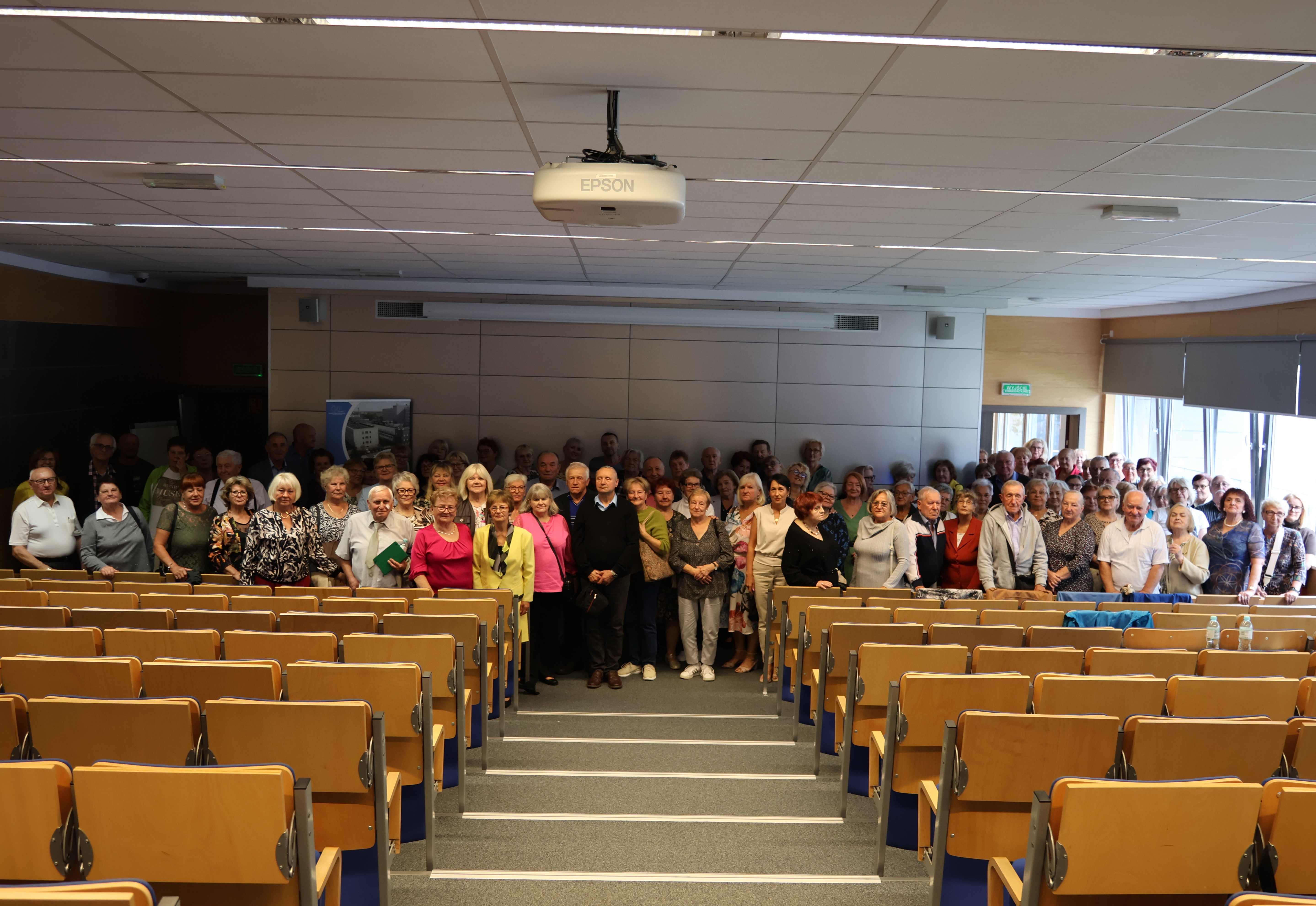Spotkanie edukacyjne z Seniorami. Zdjęcie grupowe uczestników Wirtualnego Klubu Seniora w auli Wojewódzkiego Szpitala Specjalistycznego w Białej Podlaskiej.